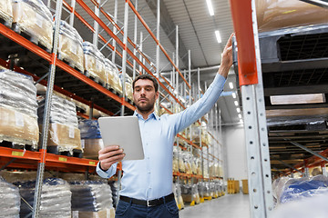 Image showing businessman with tablet pc at warehouse