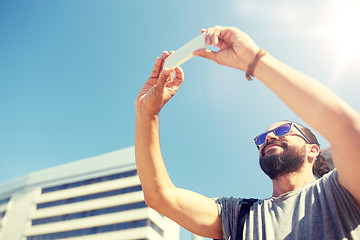 Image showing man taking video or selfie by smartphone in city