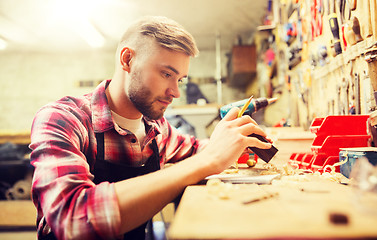 Image showing carpenter working with wood plank at workshop