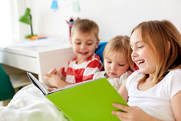 Image showing little kids reading book in bed at home