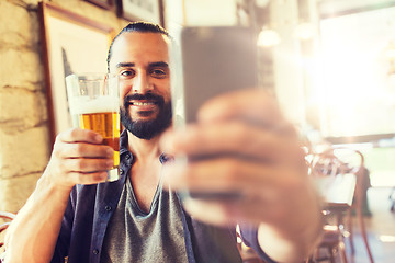 Image showing man with smartphone drinking beer at bar or pub