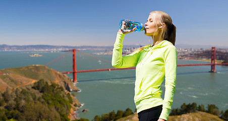 Image showing woman drinking water after doing sports outdoors