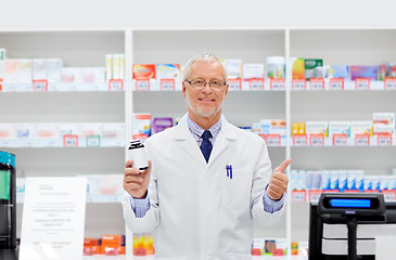 Image showing senior apothecary with drug at pharmacy