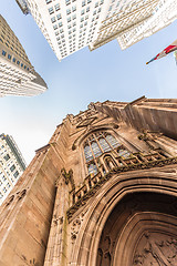 Image showing Wide angle upward view of Trinity Church at Broadway and Wall Street with surrounding skyscrapers, Lower Manhattan, New York City, USA