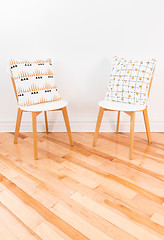 Image showing Stylish chairs with ornamental cushions on hardwood floor