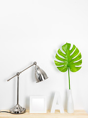 Image showing Elegant home decor with metal lamp and tropical leaf