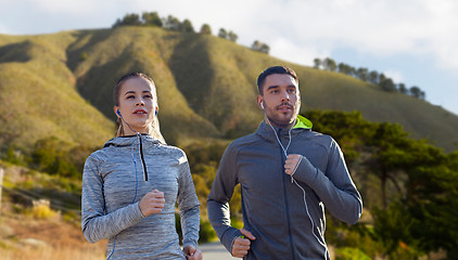 Image showing couple with earphones running over big sur