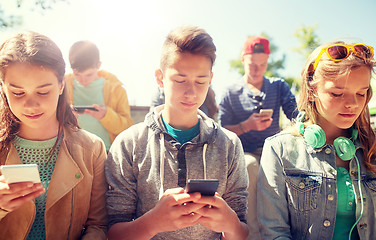 Image showing group of teenage friends with smartphones outdoors