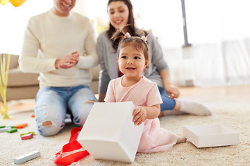 Image showing baby girl with birthday gift and parents at home