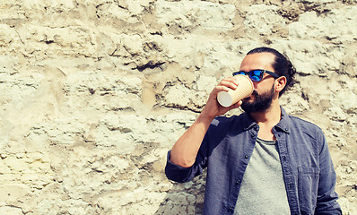 Image showing man drinking coffee from paper cup on street