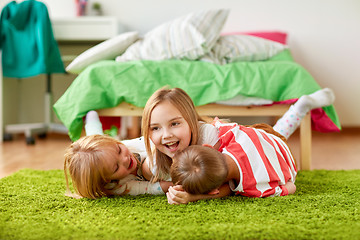 Image showing happy little kids lying on floor or carpet