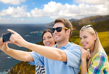 Image showing group of happy friends taking selfie by cell phone