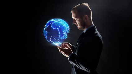 Image showing businessman with tablet pc and earth hologram