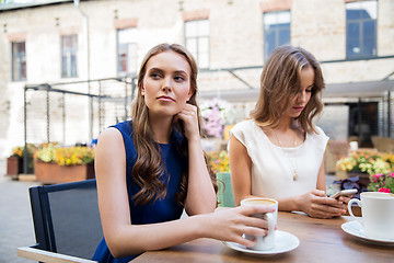 Image showing young women with smartphone and coffee at cafe