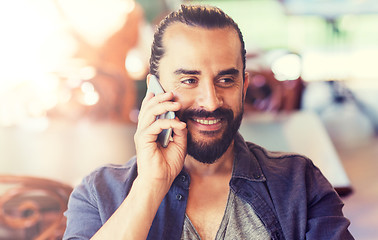 Image showing happy man calling on smartphone at bar or pub