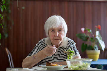 Image showing Solitary senior woman eating her lunch at retirement home.