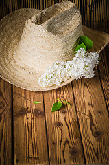 Image showing Still-life with a bouquet of lilacs and a straw hat, close-up