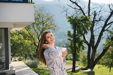 Image showing woman in a bathrobe enjoying morning coffee