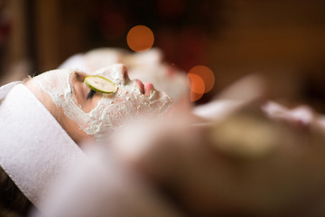 Image showing woman is getting facial clay mask at spa