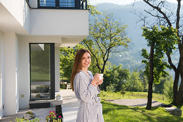 Image showing woman in a bathrobe enjoying morning coffee