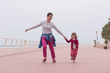 Image showing mother and cute little girl on the promenade by the sea