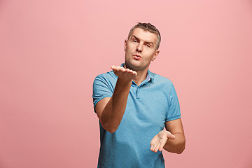 Image showing Portrait of attractive man with kiss isolated over pink background