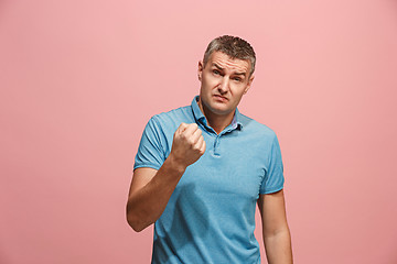 Image showing Beautiful male half-length portrait isolated on pink studio backgroud. The young emotional surprised man