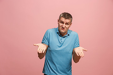 Image showing Beautiful male half-length portrait isolated on pink studio backgroud. The young emotional surprised man