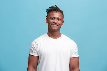 Image showing The happy afro-american business man standing and smiling against blue background.