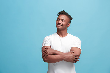 Image showing The happy business afro-american man standing and smiling against blue background.