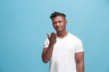 Image showing Portrait of attractive Afro-American man with air kiss isolated over blue background