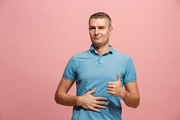 Image showing The happy business man standing and smiling against pink background.