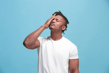 Image showing African American Man having headache. Isolated over blue background.