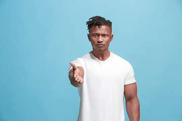 Image showing The overbearing afro-american businessman point you and want you, half length closeup portrait on blue background.