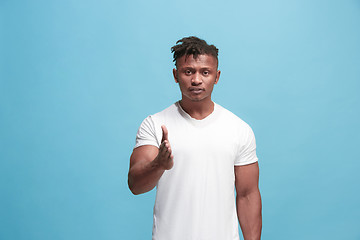 Image showing The overbearing afro-american businessman point you and want you, half length closeup portrait on blue background.