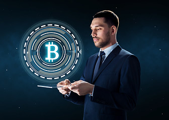 Image showing businessman with tablet pc and bitcoin hologram