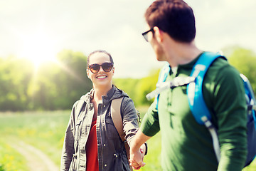 Image showing happy couple with backpacks hiking outdoors