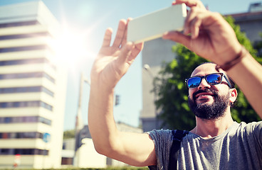 Image showing man taking video or selfie by smartphone in city