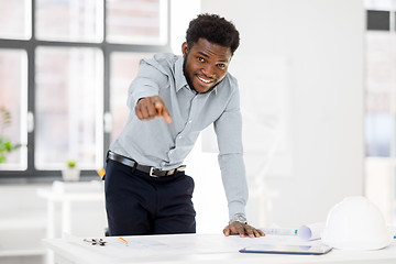 Image showing african architect with blueprint pointing at you