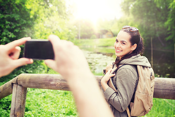 Image showing couple with backpacks taking picture by smartphone