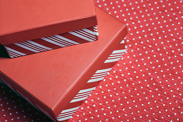 Image showing Christmas gift boxes on a red wrapping paper