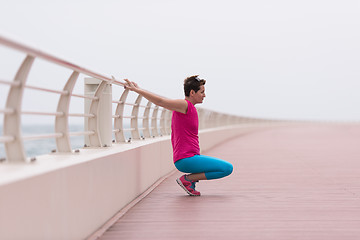 Image showing woman stretching and warming up on the promenade