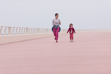 Image showing mother and cute little girl on the promenade by the sea