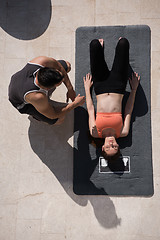 Image showing woman with personal trainer doing morning yoga exercises top vie