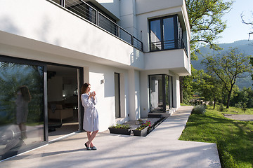 Image showing woman in a bathrobe enjoying morning coffee