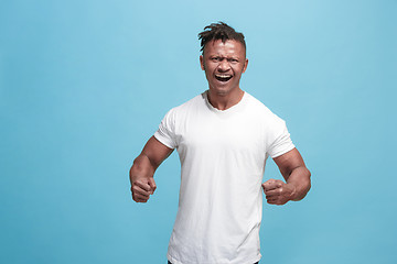 Image showing The young emotional angry afro man screaming on blue studio background