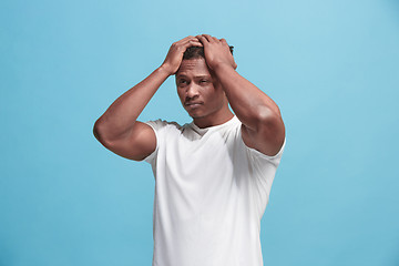 Image showing African American Man having headache. Isolated over blue background.