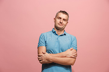 Image showing The happy business man standing and smiling against pink background.