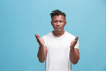 Image showing Portrait of attractive Afro-American man with air kiss isolated over blue background