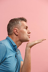 Image showing Portrait of attractive man with kiss isolated over pink background